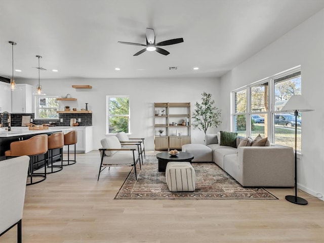 living room featuring ceiling fan and light hardwood / wood-style floors