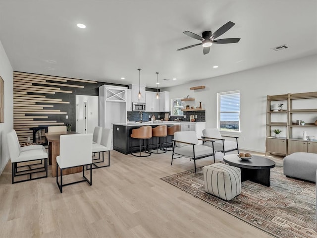 living room featuring ceiling fan and light wood-type flooring