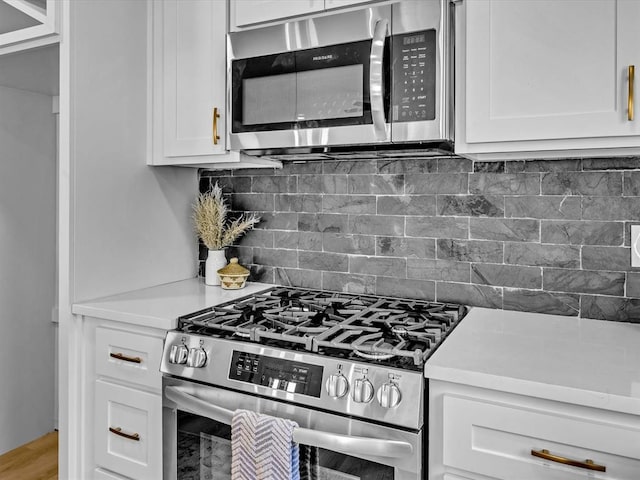 kitchen with white cabinets, backsplash, and stainless steel appliances