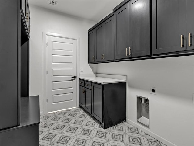 washroom featuring electric dryer hookup and cabinets