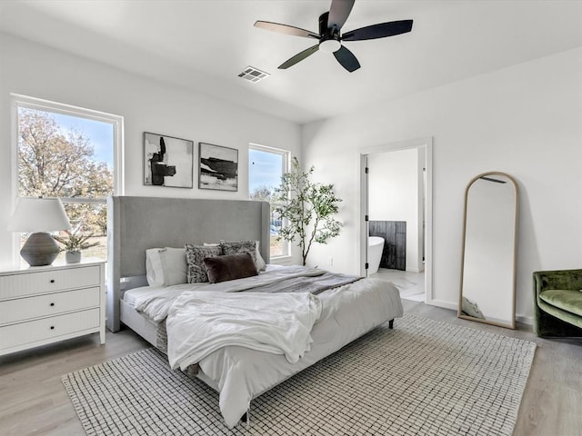 bedroom featuring connected bathroom, light hardwood / wood-style floors, and ceiling fan