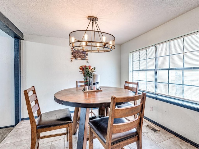 dining room featuring a chandelier and a textured ceiling