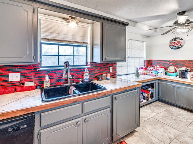 kitchen with dishwasher, backsplash, gray cabinets, and sink