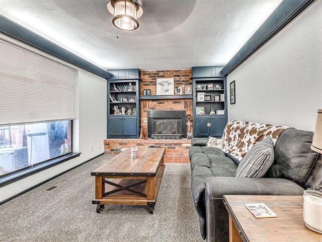 carpeted living room with built in shelves, a textured ceiling, and a brick fireplace