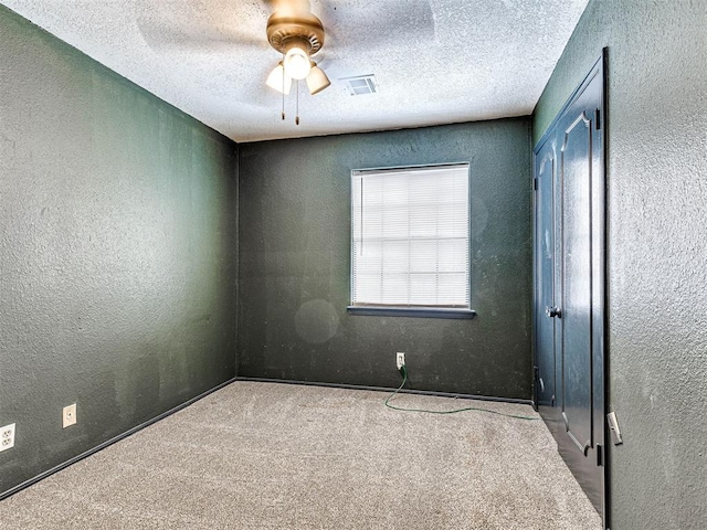 unfurnished room featuring light carpet, a textured ceiling, and ceiling fan