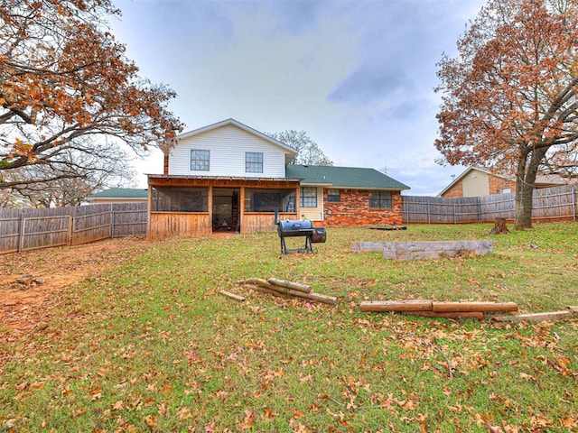 back of property with a yard and a sunroom