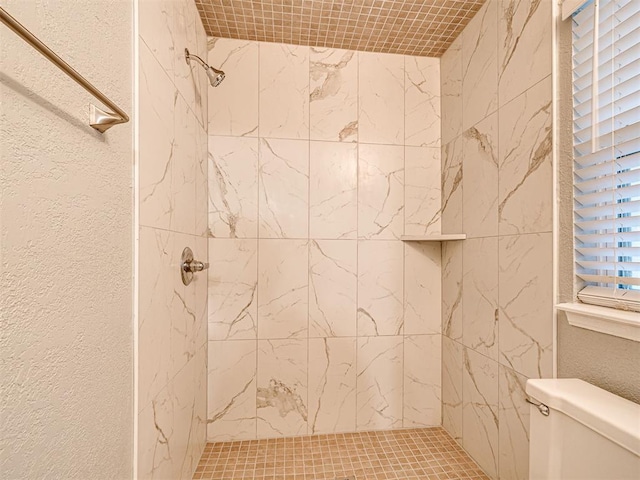 bathroom featuring toilet and tiled shower