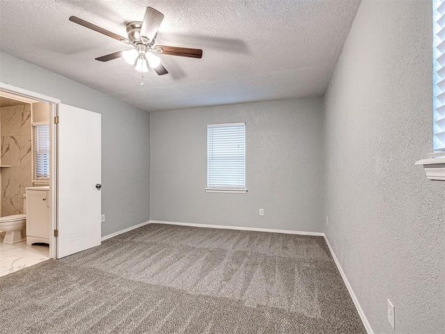 spare room featuring a textured ceiling, light colored carpet, and ceiling fan