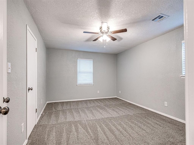 carpeted spare room with ceiling fan and a textured ceiling