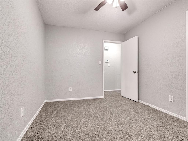 spare room featuring carpet flooring, ceiling fan, and a textured ceiling