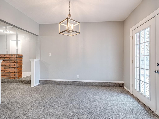 empty room with carpet and a notable chandelier