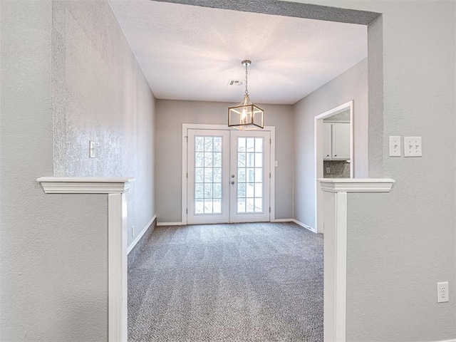 doorway to outside featuring carpet floors, a textured ceiling, and french doors