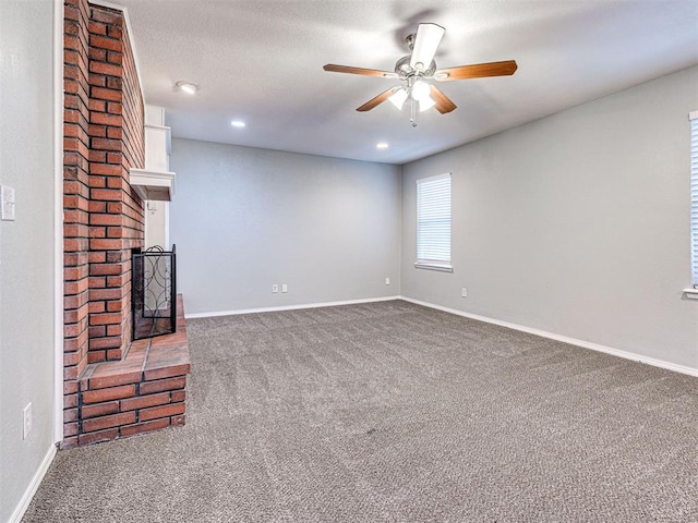 unfurnished living room with ceiling fan, carpet, and a brick fireplace