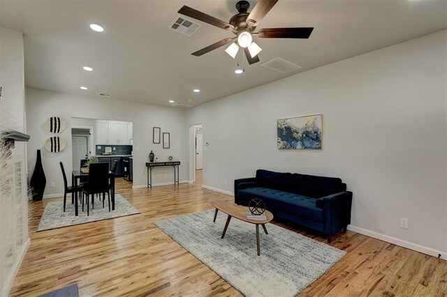 living room featuring light hardwood / wood-style floors and ceiling fan