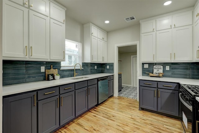 kitchen featuring gray cabinetry, dishwasher, white cabinets, sink, and light wood-type flooring