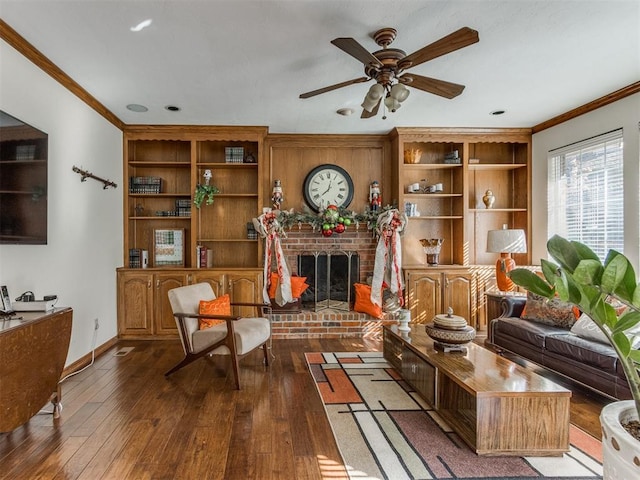 sitting room with dark hardwood / wood-style flooring, a brick fireplace, ceiling fan, and ornamental molding