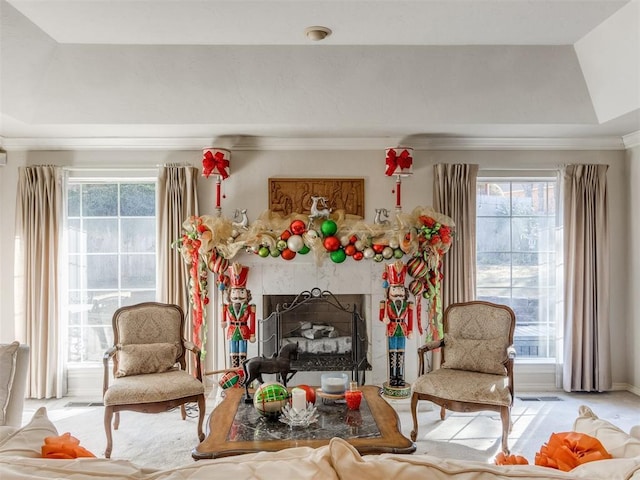 sitting room with a tray ceiling, crown molding, and a healthy amount of sunlight