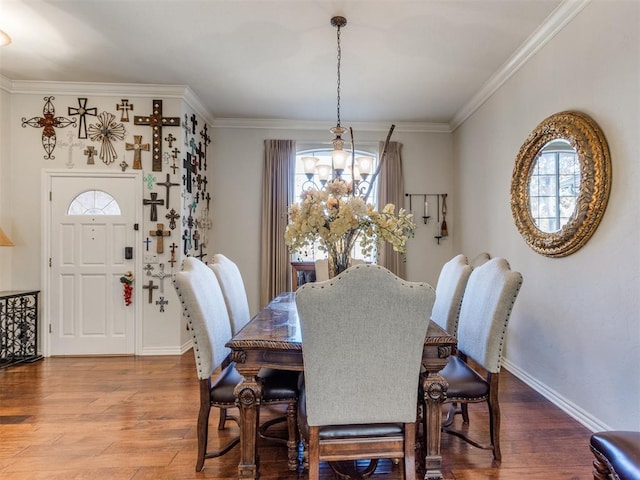 dining room with hardwood / wood-style floors, ornamental molding, and a notable chandelier