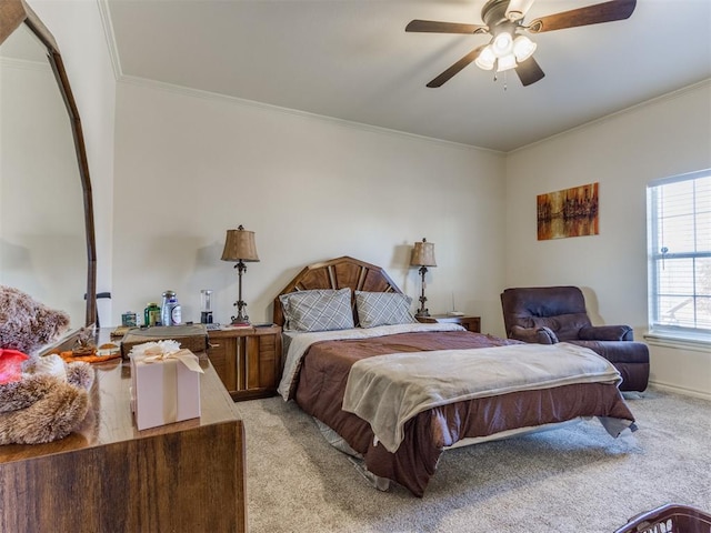 carpeted bedroom featuring ceiling fan and crown molding