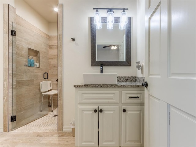 bathroom with vanity, ceiling fan, and a shower with shower door