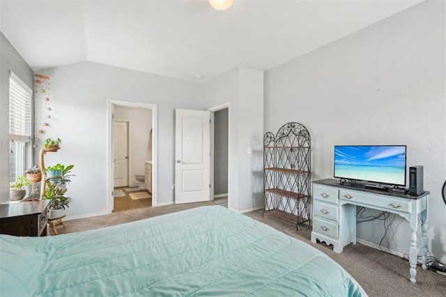 carpeted bedroom with ensuite bath and vaulted ceiling