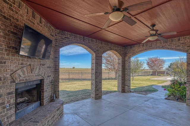 view of patio with ceiling fan and a fireplace