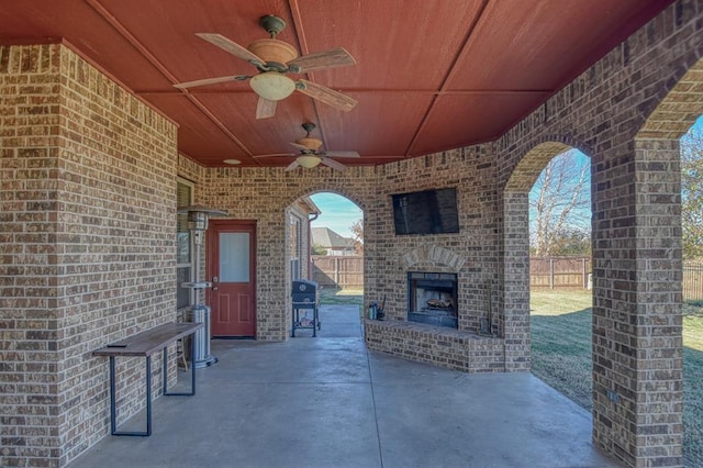 view of patio / terrace with area for grilling, an outdoor brick fireplace, and ceiling fan