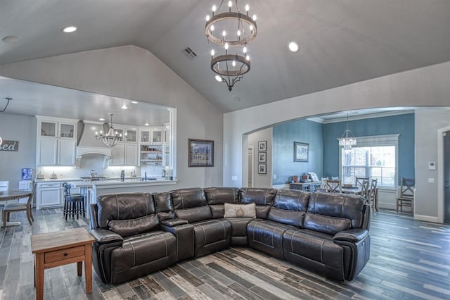 living room featuring dark wood-type flooring, high vaulted ceiling, and an inviting chandelier