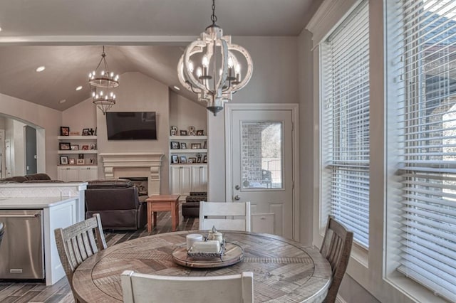 dining area with built in shelves, a chandelier, wood-type flooring, and vaulted ceiling