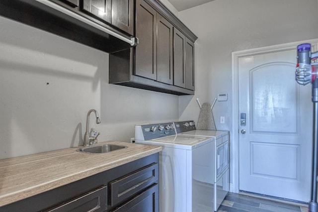 laundry room featuring cabinets, separate washer and dryer, dark wood-type flooring, and sink