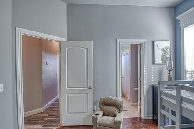 bedroom featuring connected bathroom and dark hardwood / wood-style floors