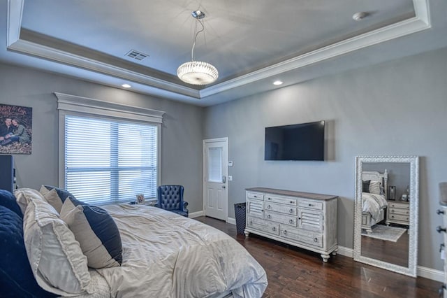 bedroom featuring dark hardwood / wood-style floors, crown molding, and a tray ceiling