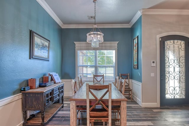 dining space with a chandelier, dark wood-type flooring, and ornamental molding