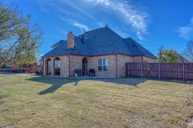 back of house featuring a patio area and a yard