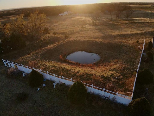 aerial view at dusk featuring a water view and a rural view