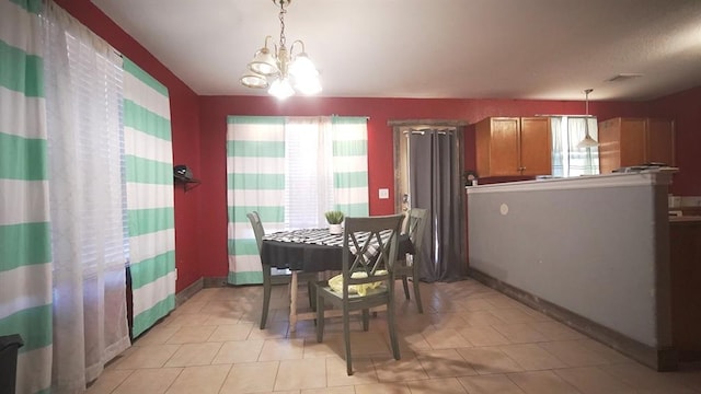 dining area featuring light tile patterned flooring and an inviting chandelier