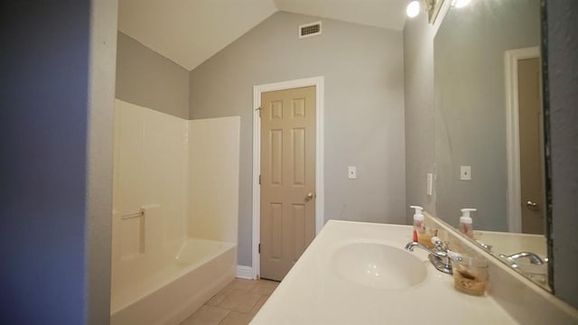 bathroom with tile patterned flooring, vanity, shower / bathtub combination, and lofted ceiling