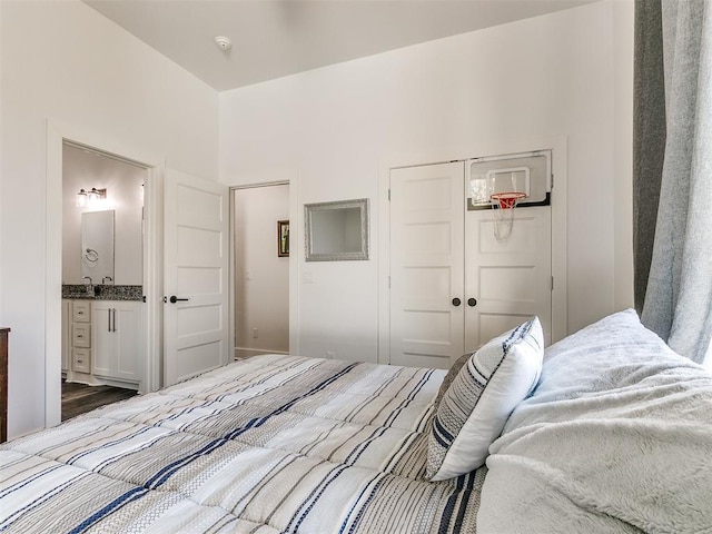 bedroom featuring ensuite bathroom, dark hardwood / wood-style flooring, sink, and a closet