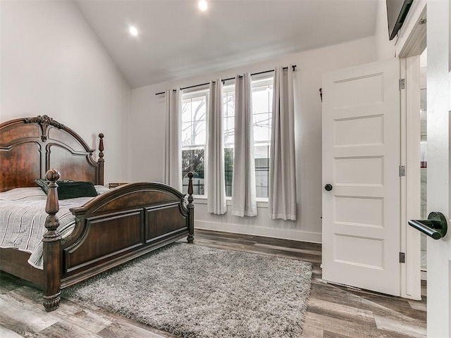 bedroom with hardwood / wood-style floors and vaulted ceiling