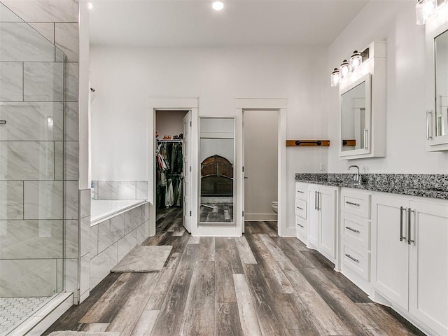 full bathroom with toilet, vanity, independent shower and bath, and hardwood / wood-style flooring