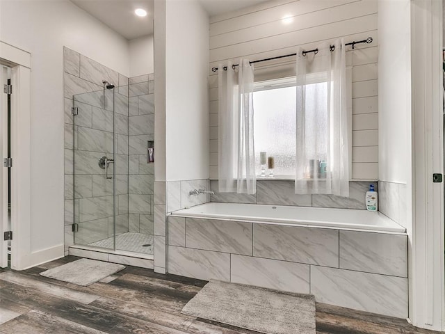 bathroom featuring hardwood / wood-style floors and separate shower and tub