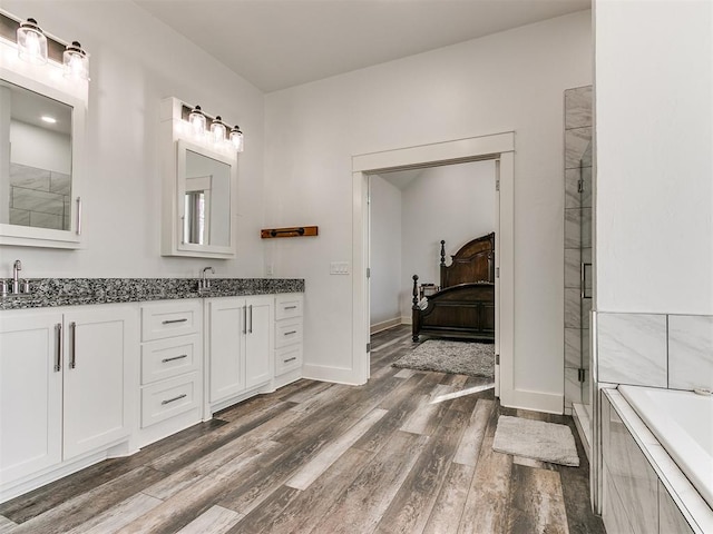 bathroom featuring independent shower and bath, vanity, and wood-type flooring