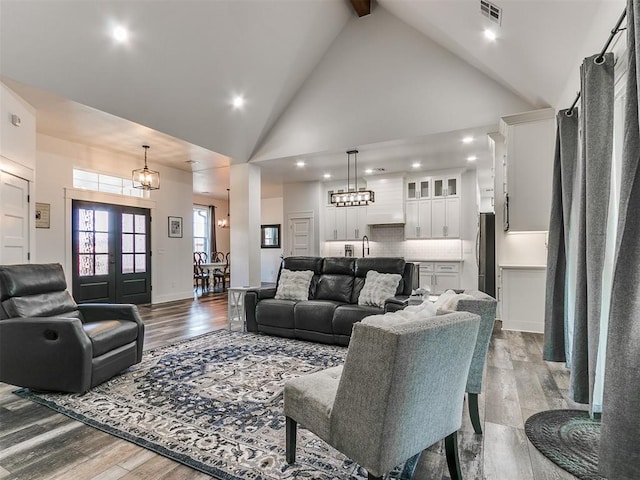 living room with beam ceiling, sink, high vaulted ceiling, and light hardwood / wood-style flooring