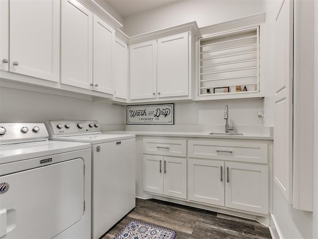 laundry area with washer and clothes dryer, cabinets, sink, and dark wood-type flooring