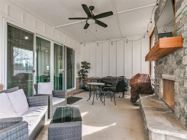 view of patio with an outdoor living space with a fireplace and ceiling fan