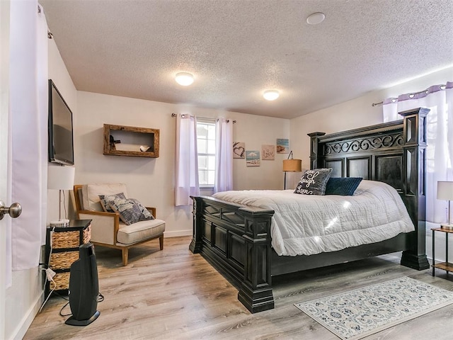 bedroom with a textured ceiling and light wood-type flooring