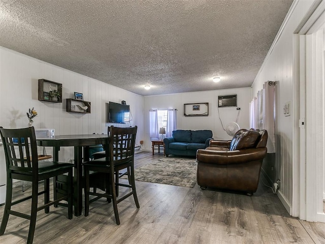 dining room with crown molding, wood-type flooring, a textured ceiling, and a wall mounted AC