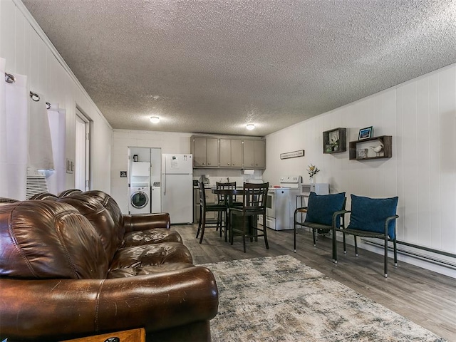 living room with a textured ceiling, dark hardwood / wood-style floors, and washer / clothes dryer