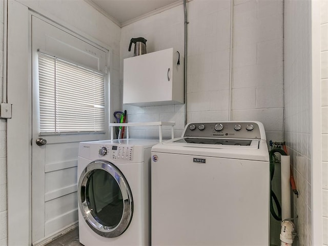 laundry room featuring tile walls and washing machine and clothes dryer