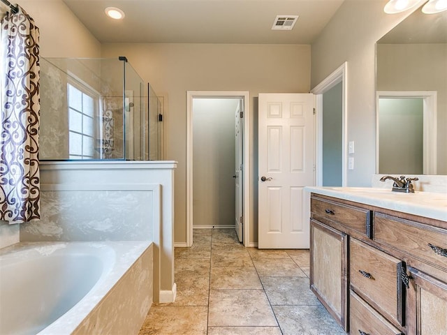 bathroom with vanity and shower with separate bathtub